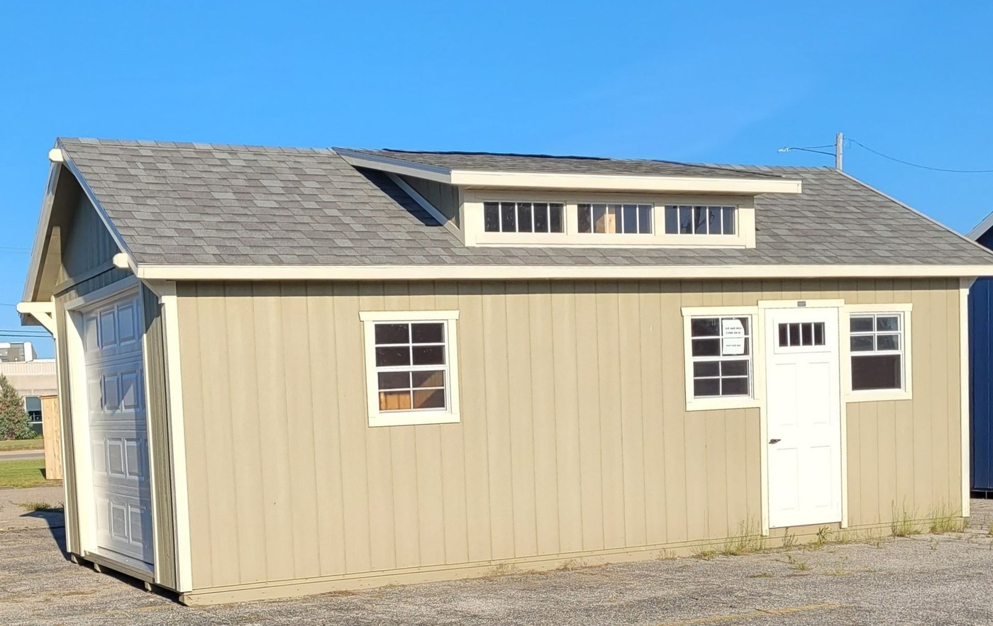A tan garage with a dormer