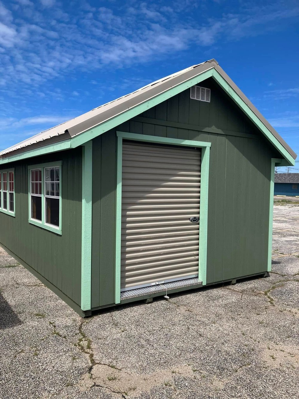 A green shed with a roll-up door