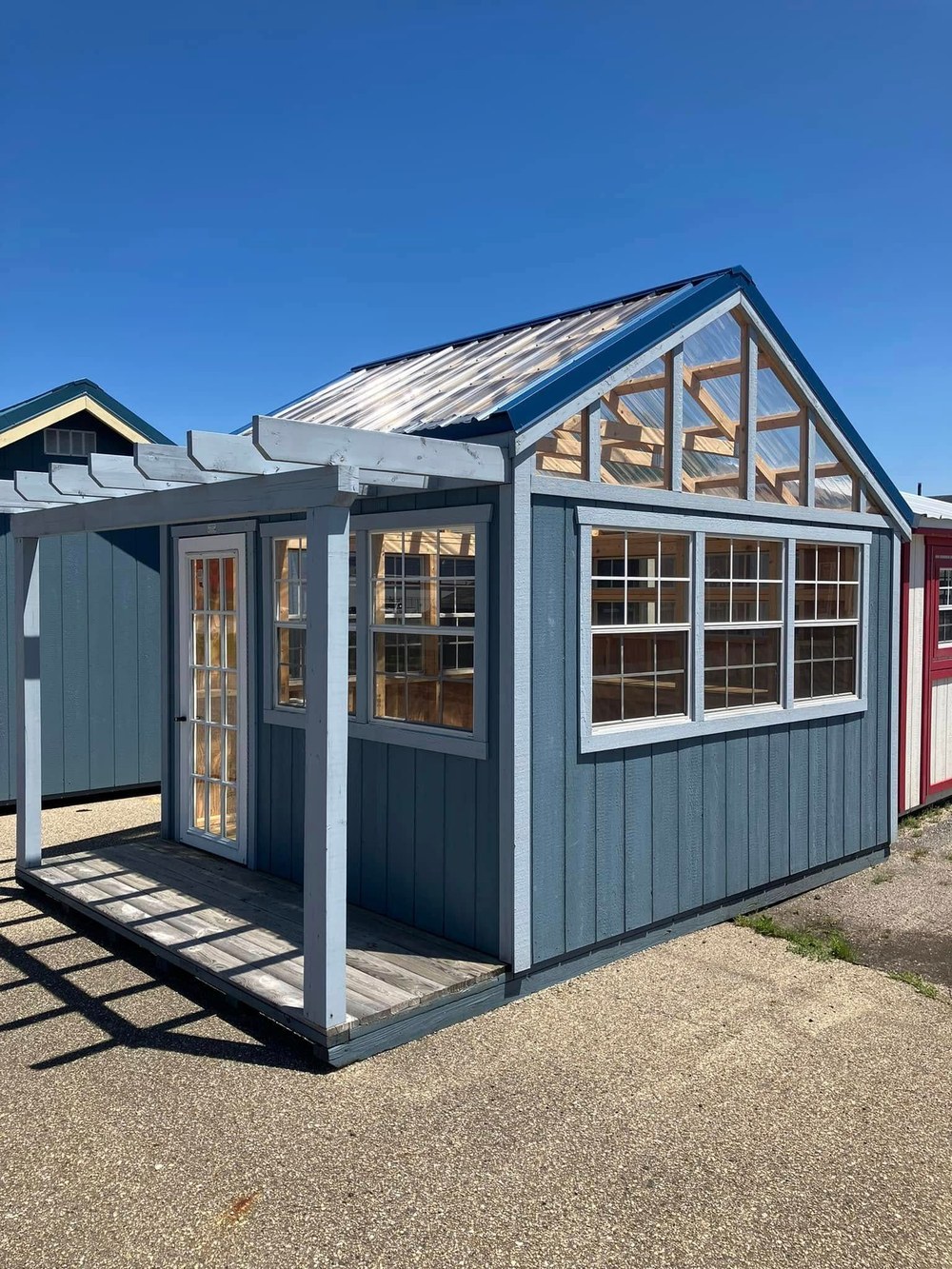 A blue potting shed with greenhouse windows
