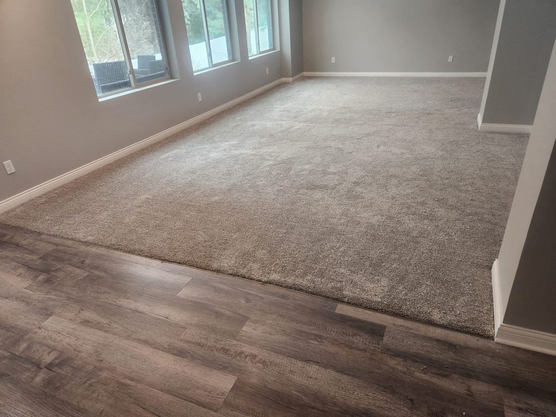 A finished basement with new beige carpet