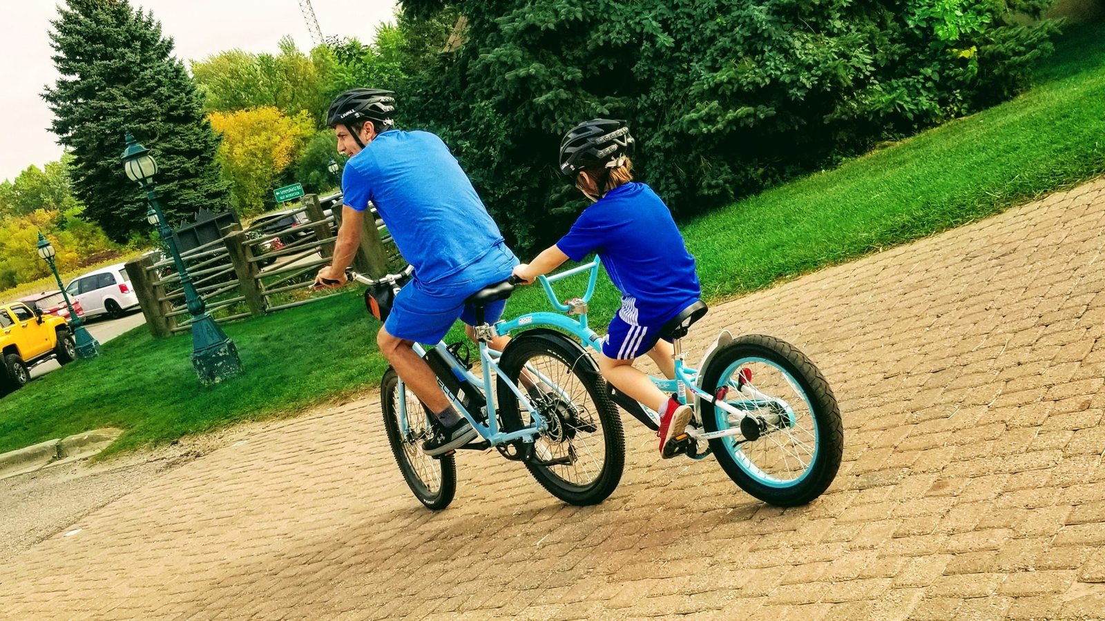 Two riders on a brick path