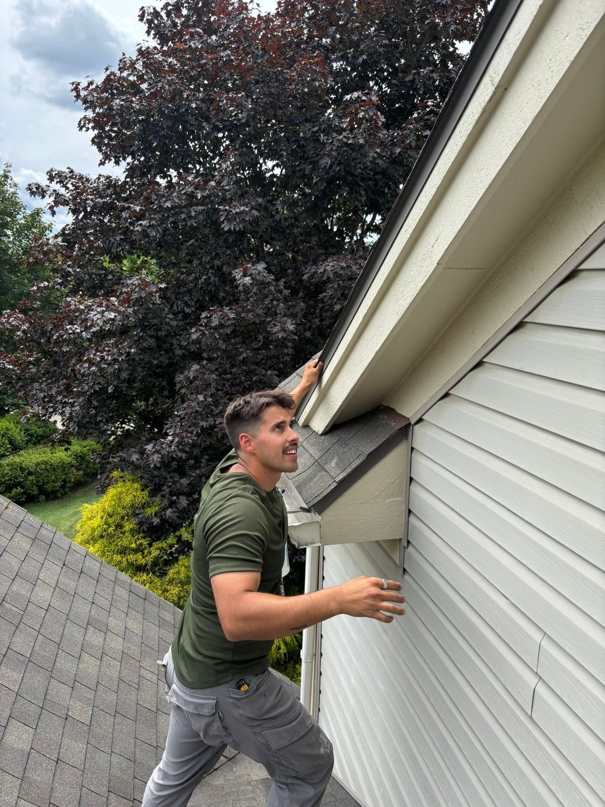 Nick from FenGuard checking the soffit and eave of a two-storey house from the roof
