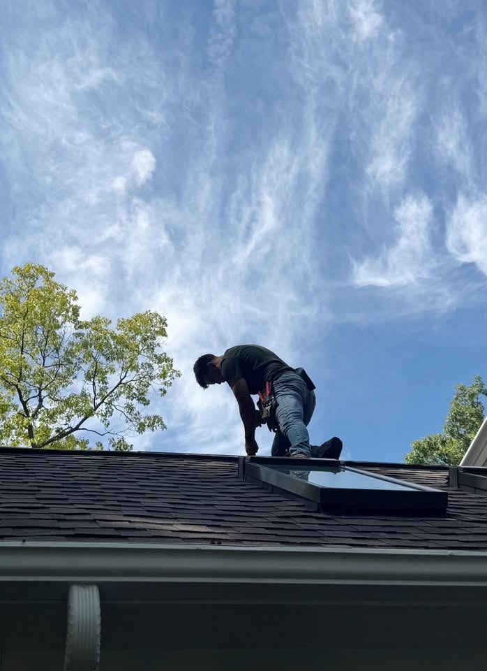 Nick crouched on a roof edge working on the flashing