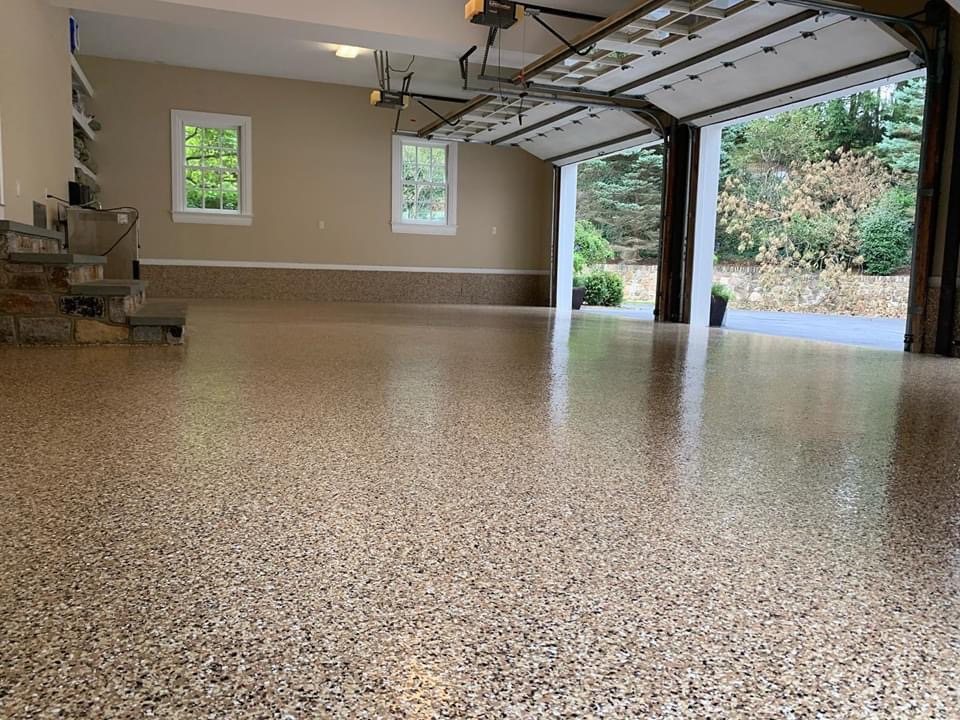A tan flake epoxy garage floor with the door open