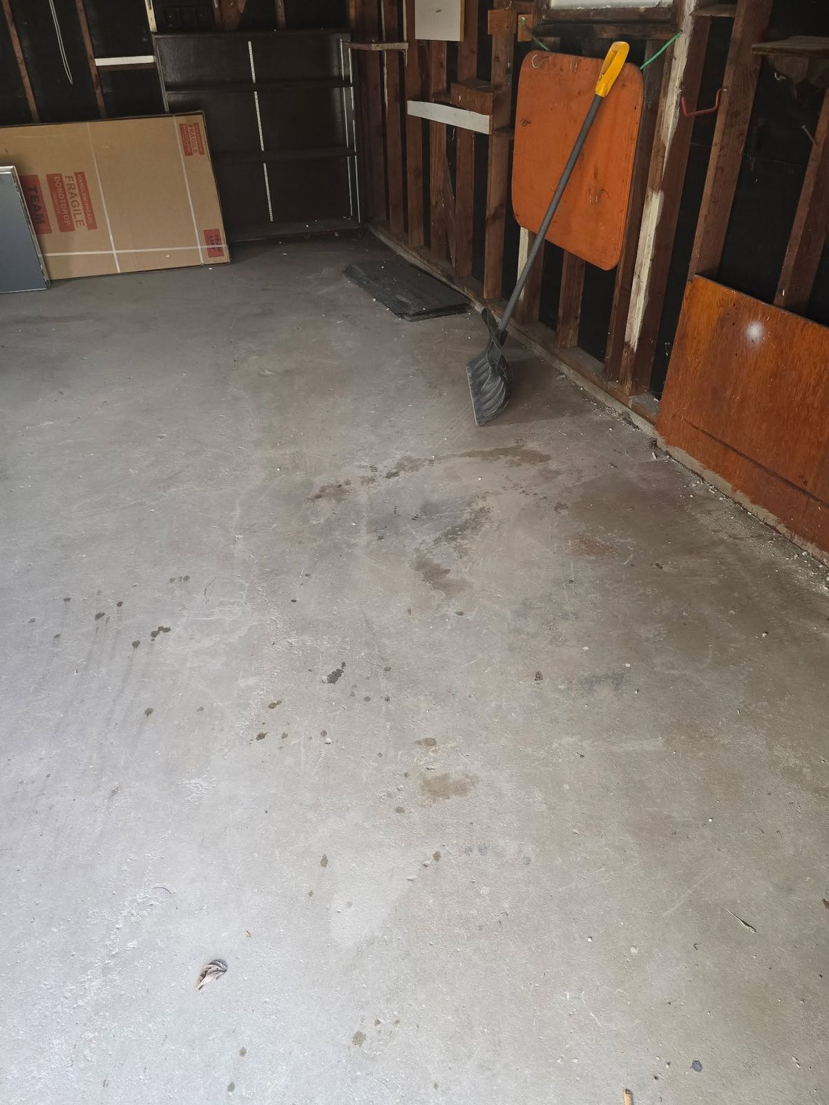 An empty garage with a swept concrete floor