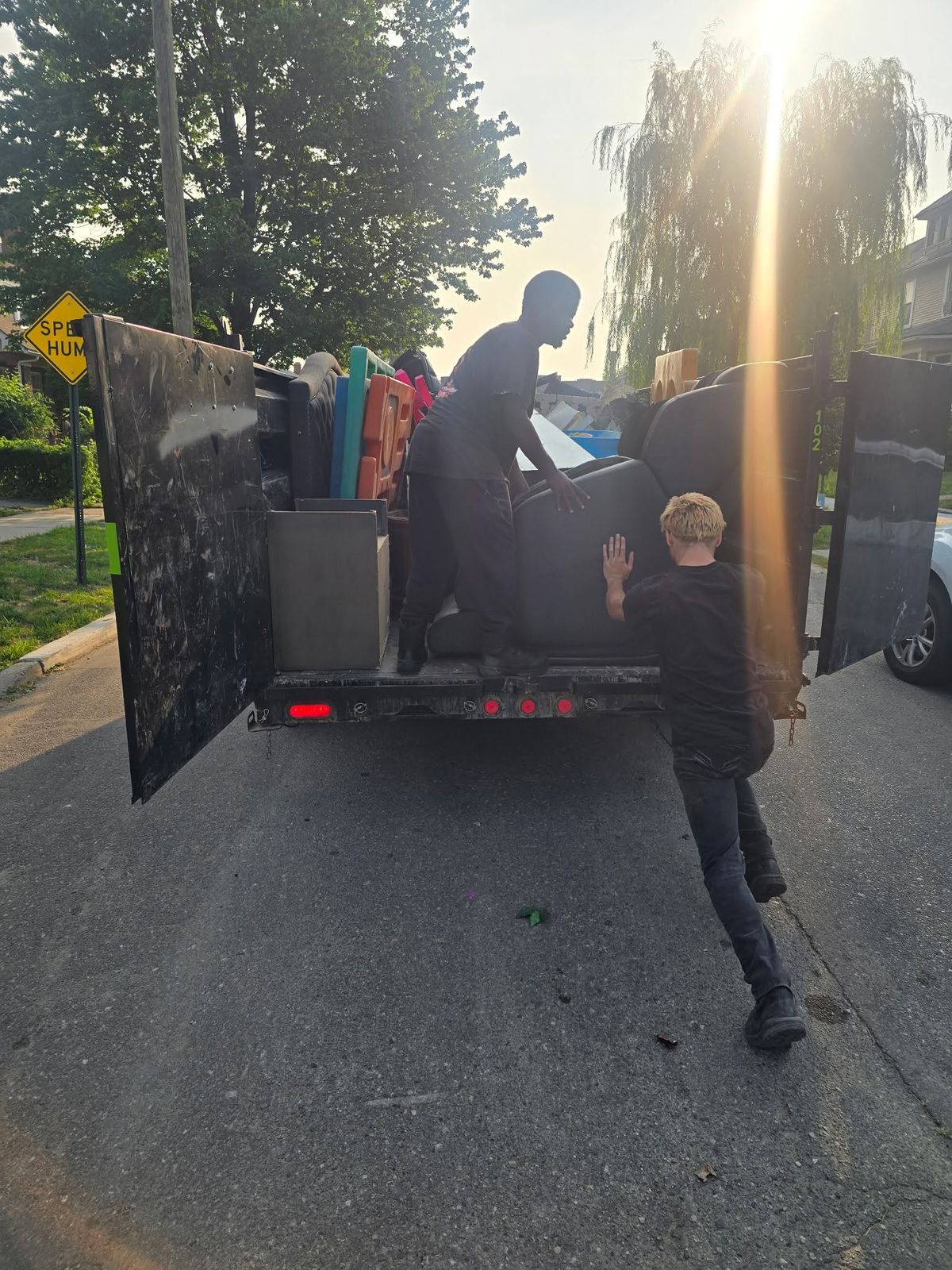 Two crew members loading furniture into the trailer early in the morning