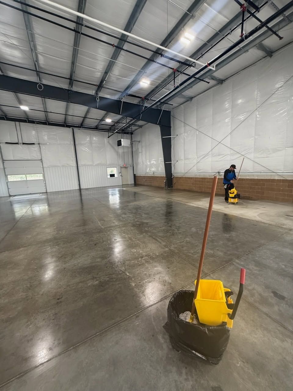 An empty commercial building with a freshly mopped concrete floor