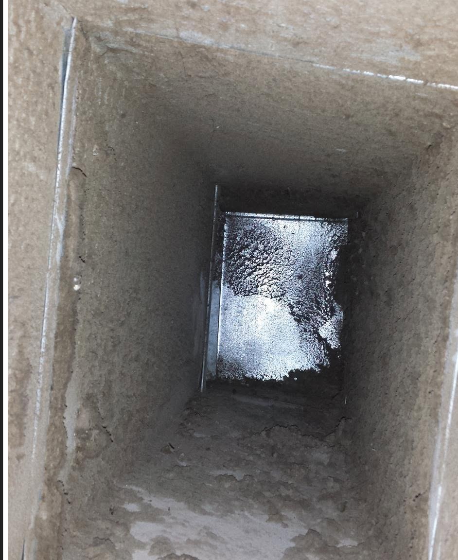A supply vent, wall to wall buildup before cleaning