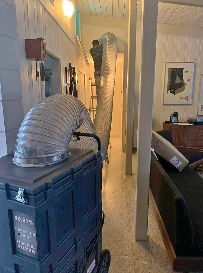 A JJ Duct Cleaning negative-air machine running inside a customer's home
