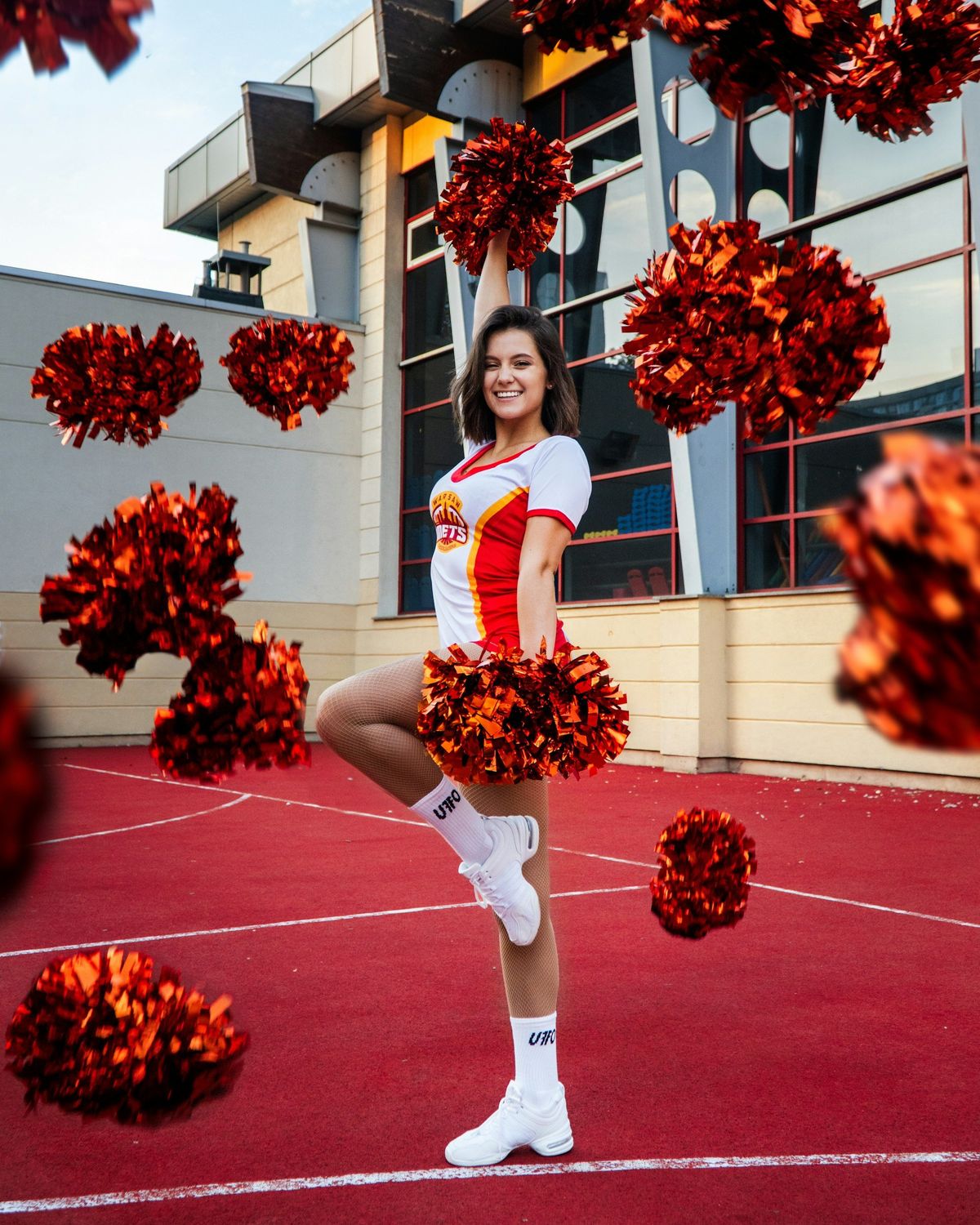 A media day portrait with red poms