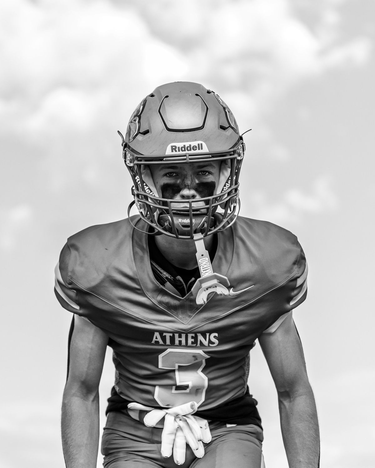 A football player in black and white, mouthguard in
