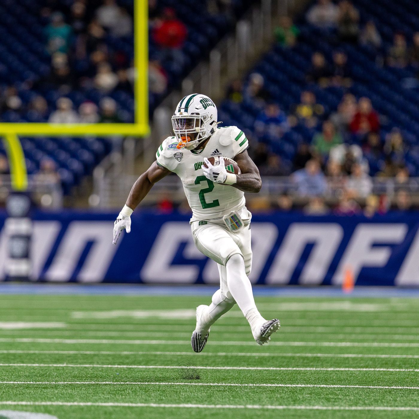 A receiver making a catch in a stadium