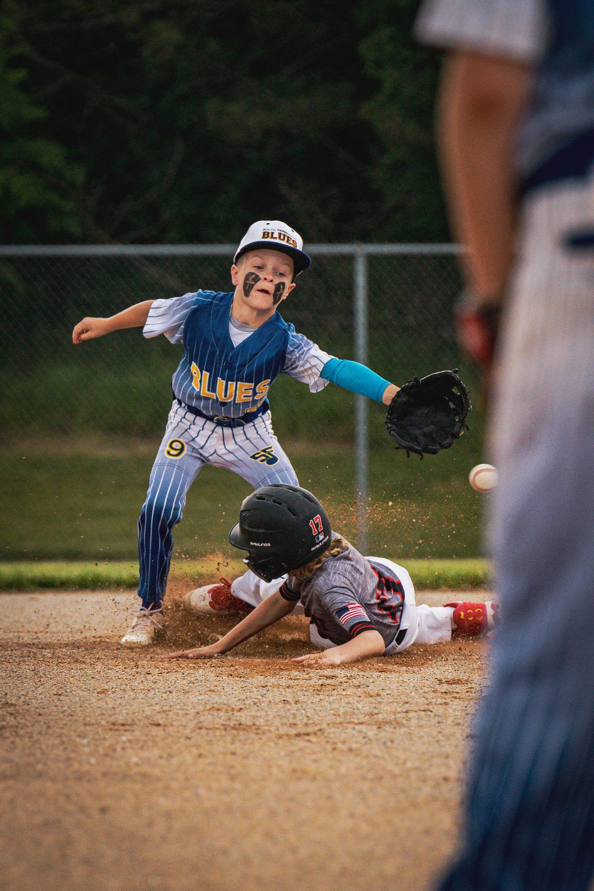 A runner sliding into the bag as the fielder reaches