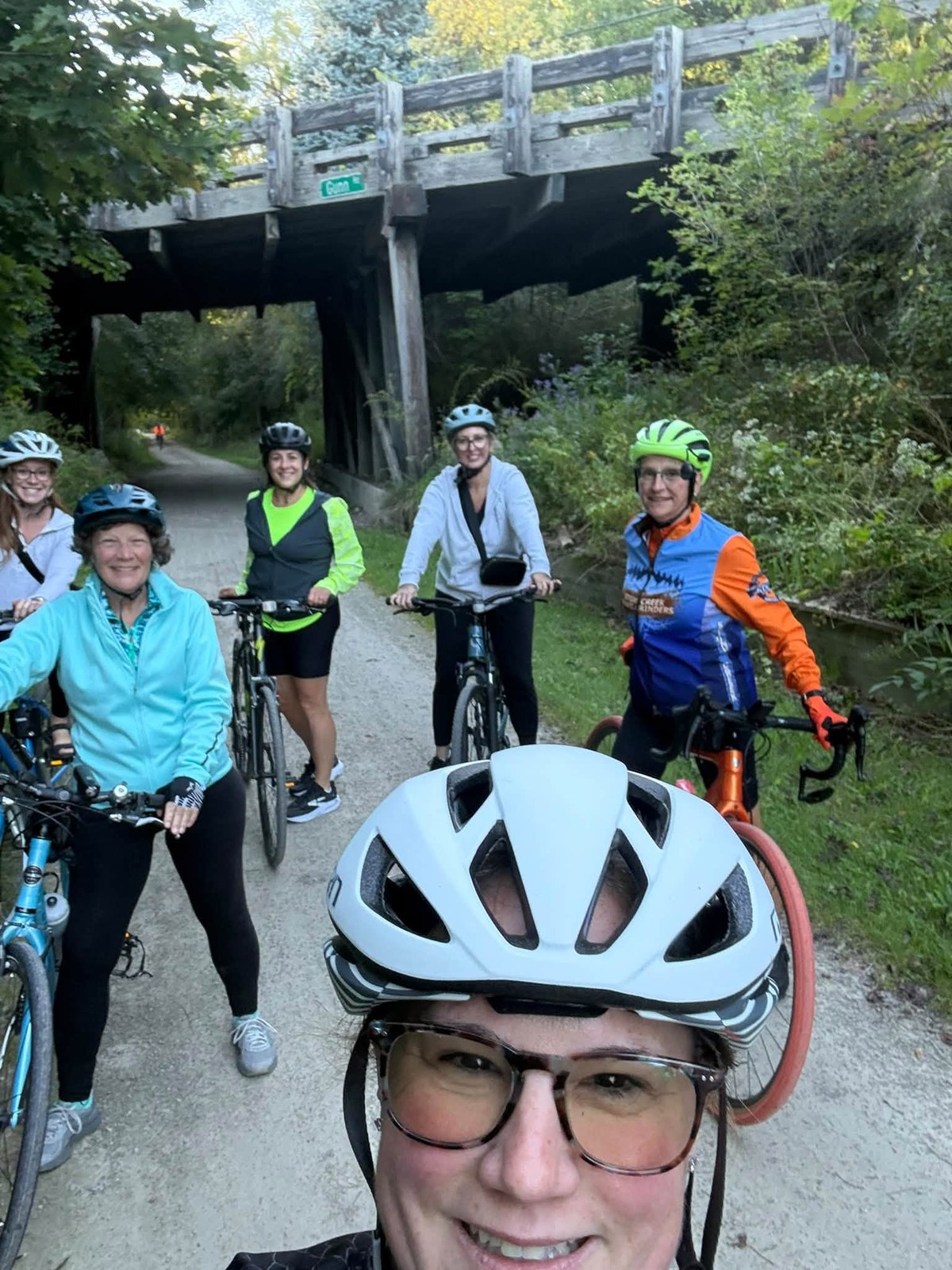 Riders on the Paint Creek Trail under a wooden bridge