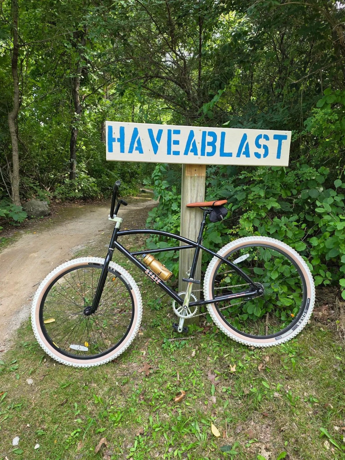 A cruiser parked by a hand-painted Have a Blast trail sign