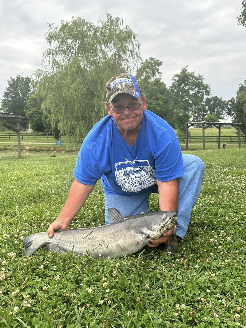 A heavy blue catfish held on the bank