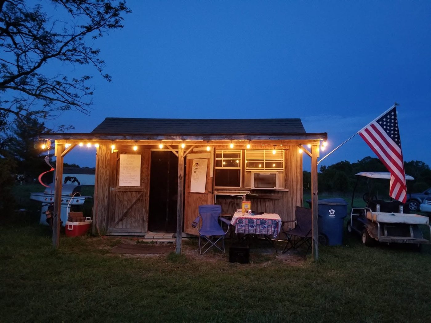 The fish shack lit up at dusk with the flag flying