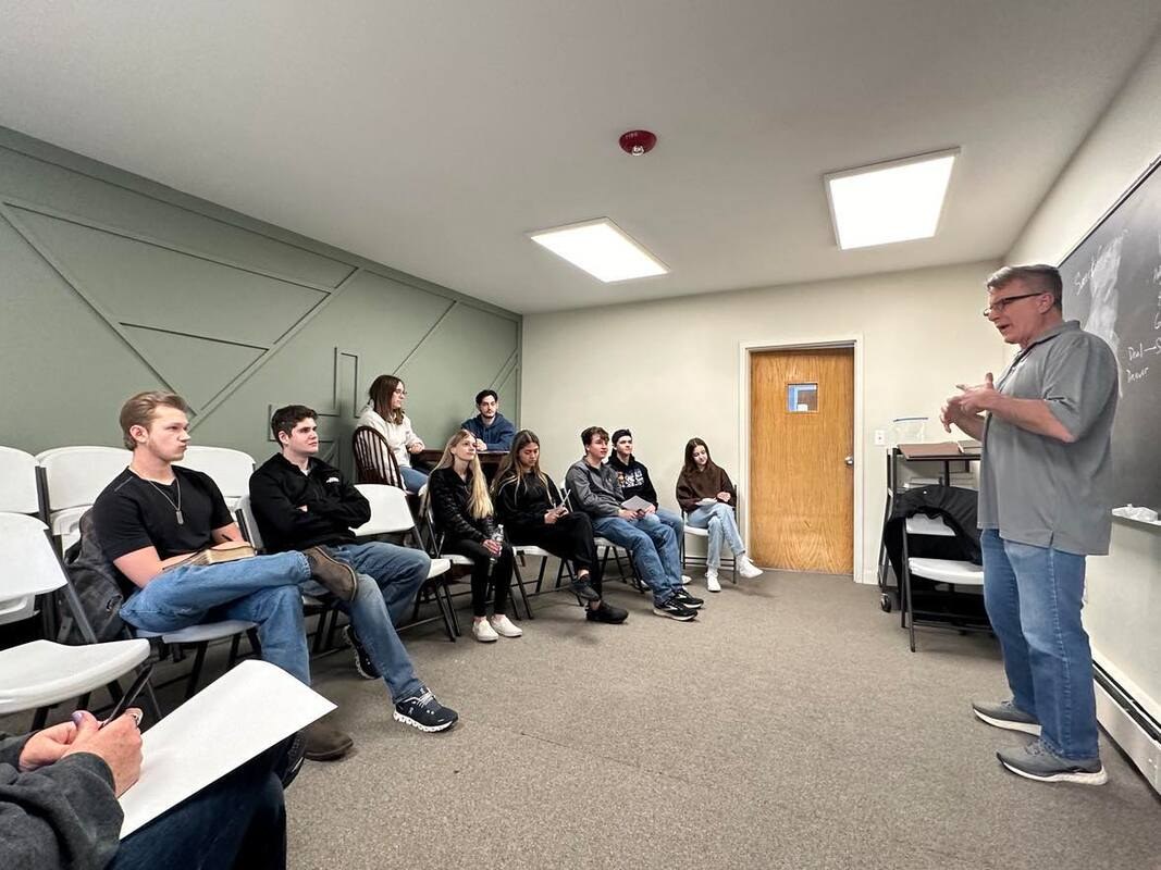An adult class gathered around a teacher