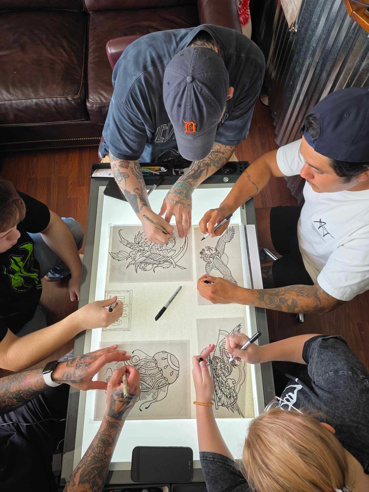 Art Night at Orchard Tattoo, people drawing around a table