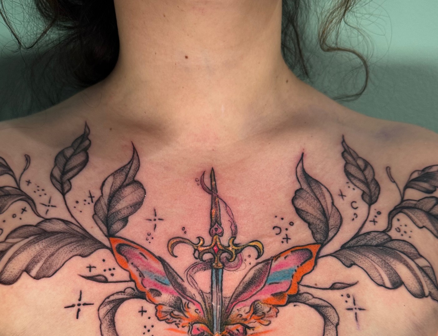 Ornamental chest piece with a dagger and butterfly wings