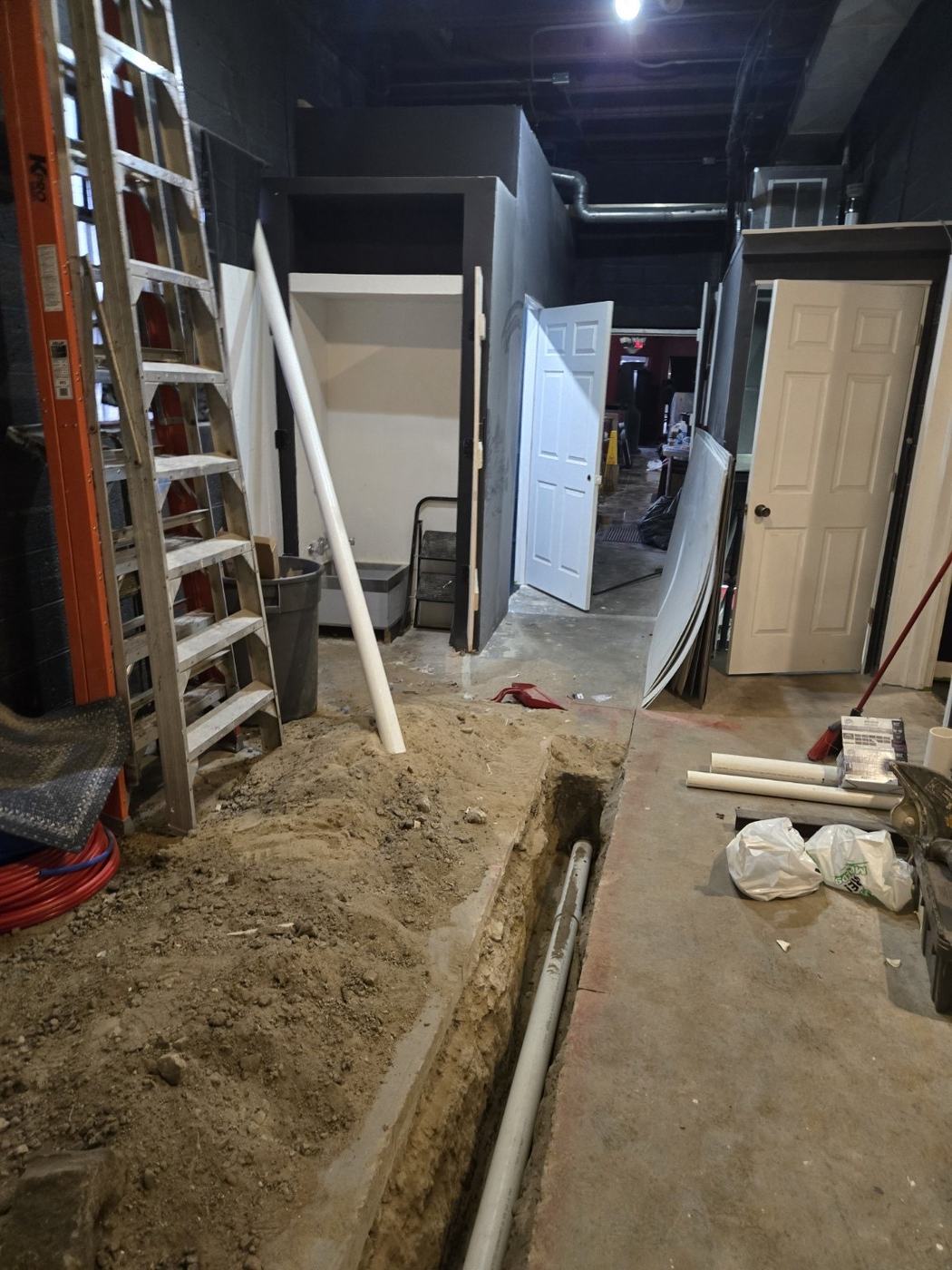 A plumbing trench cut through the floor during construction