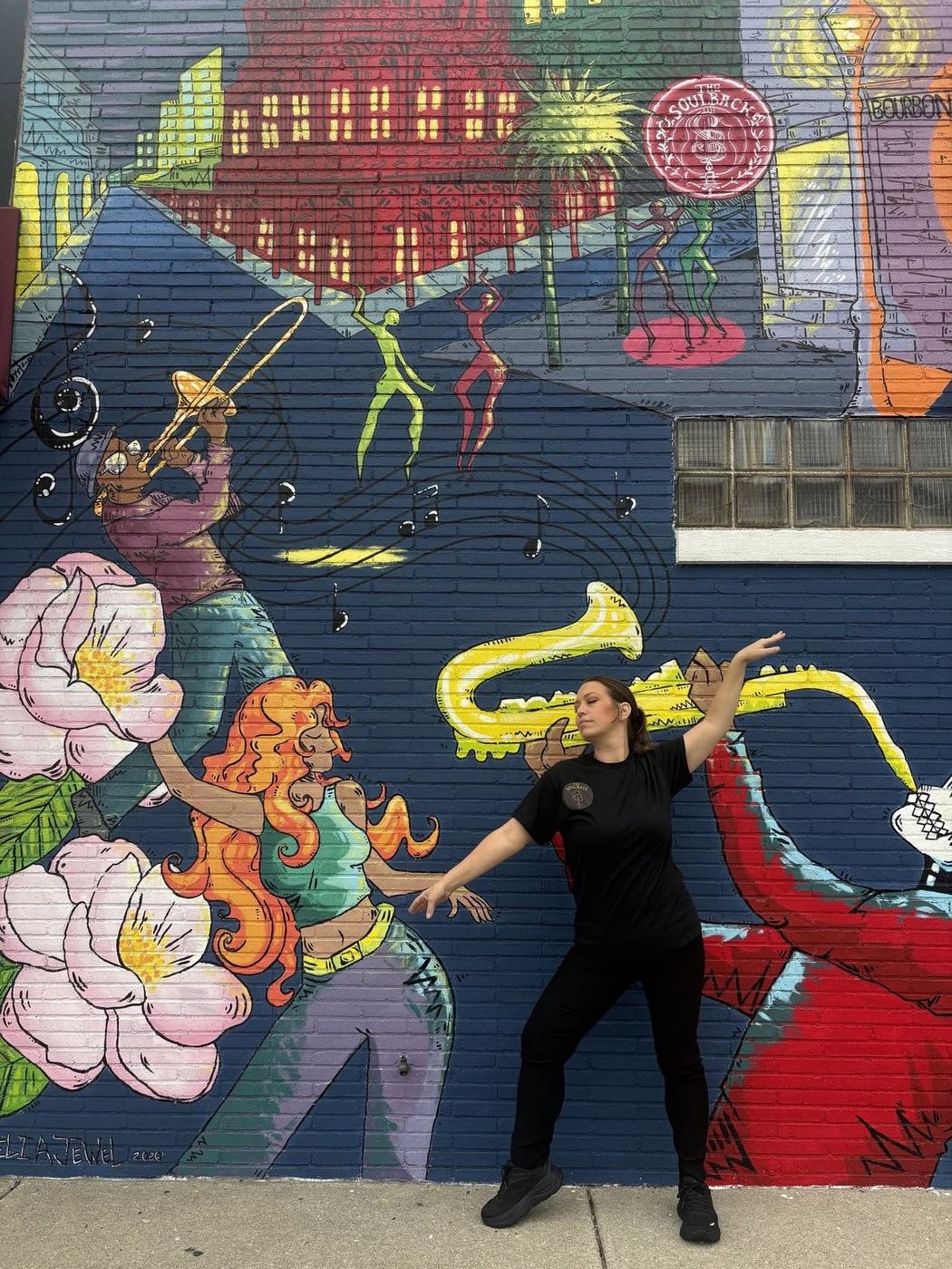 A Soulback crew member dancing in front of the jazz mural
